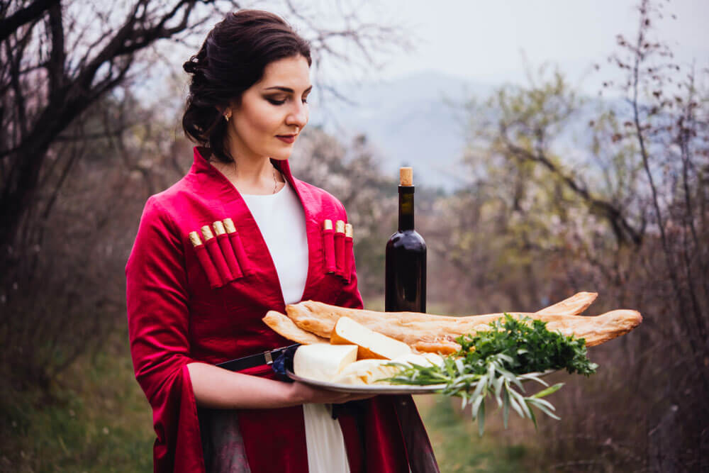 Georgian hospitality - girl holding wine and bread